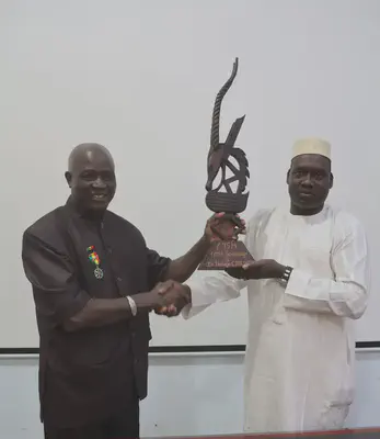 Nafogo with the director handing him a Chiwara